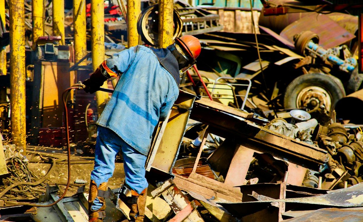 Arbeiter beim Schneiden von Schrott auf einem Recyclinghof